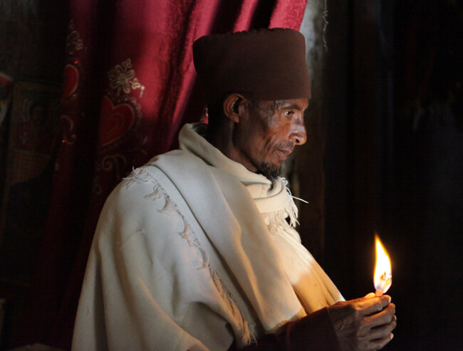 Priester mit Kerze